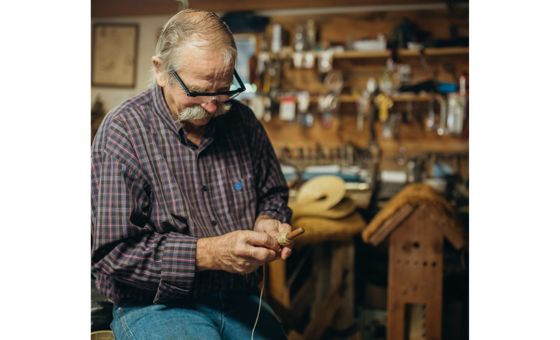 Graeme is winding up the string on the plumb bob he has just crafted.